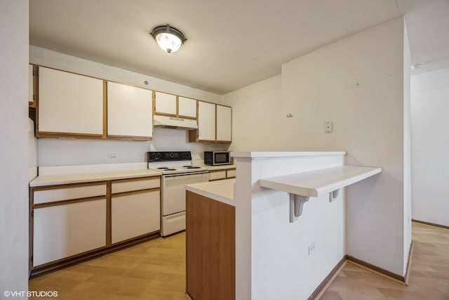 kitchen featuring white electric range oven, a peninsula, light countertops, under cabinet range hood, and stainless steel microwave