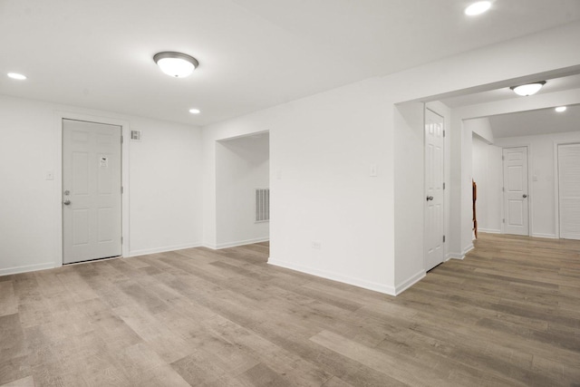 empty room with recessed lighting, visible vents, baseboards, and wood finished floors