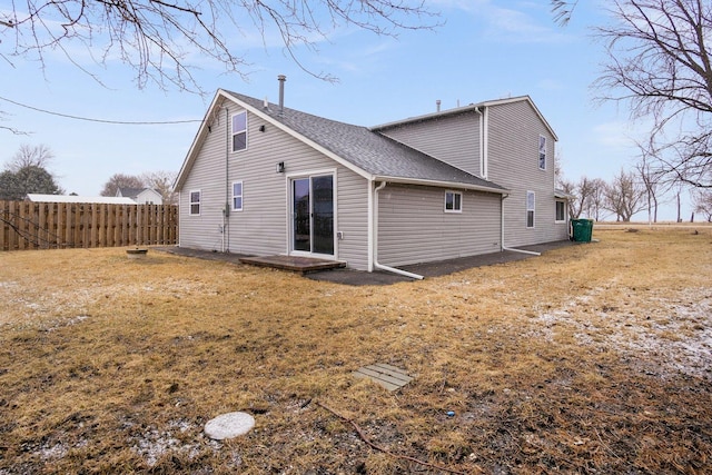 back of property featuring a yard and fence