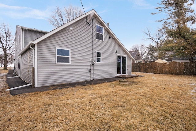 back of property featuring a yard and fence