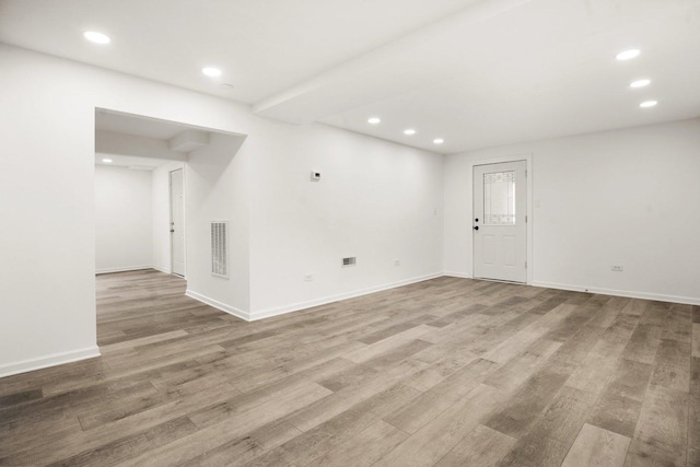 empty room featuring recessed lighting, visible vents, baseboards, and wood finished floors