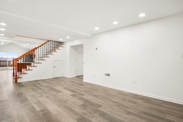 spare room featuring stairs, recessed lighting, wood finished floors, and visible vents