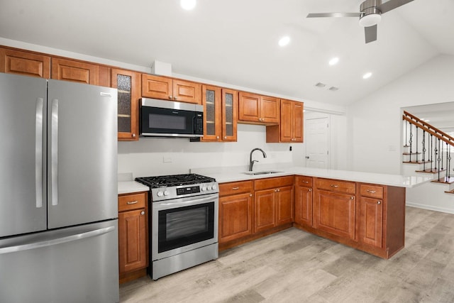 kitchen featuring glass insert cabinets, appliances with stainless steel finishes, light countertops, and a sink