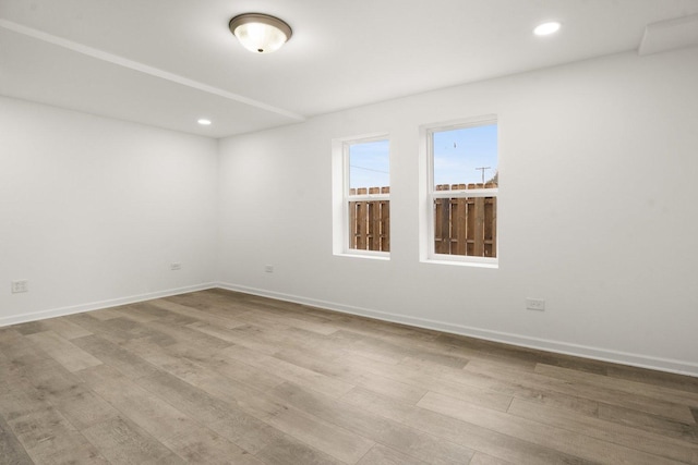 spare room with recessed lighting, wood finished floors, and baseboards