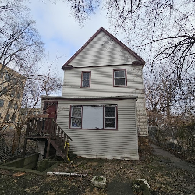 rear view of house with stairs and fence