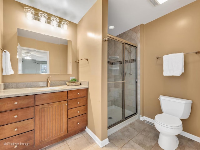 bathroom with vanity, baseboards, a stall shower, tile patterned flooring, and toilet