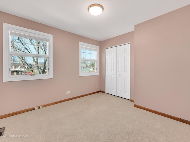 unfurnished bedroom with a closet, baseboards, and carpet flooring