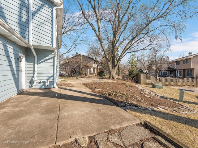 view of yard with a patio, fence, and a residential view