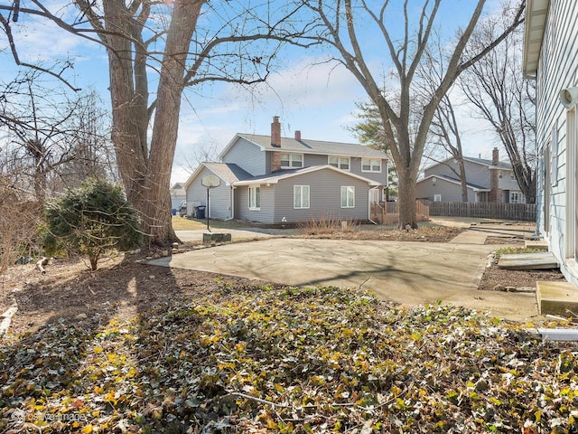 back of house featuring fence and a chimney