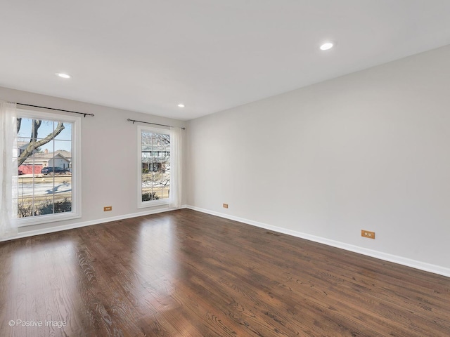 spare room featuring recessed lighting, baseboards, and dark wood-style floors