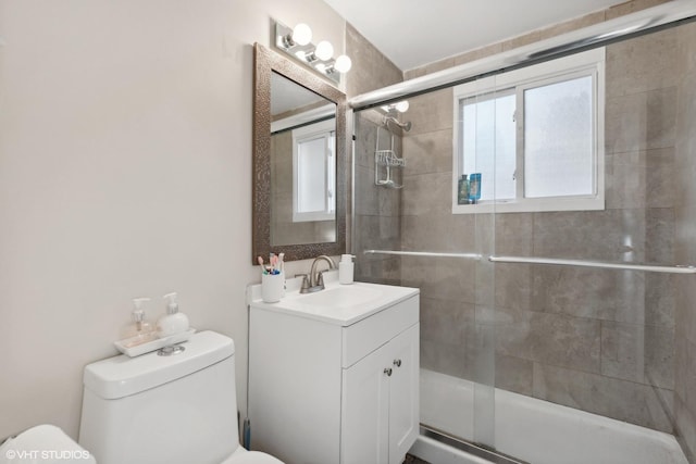 bathroom with vanity, a shower stall, and toilet