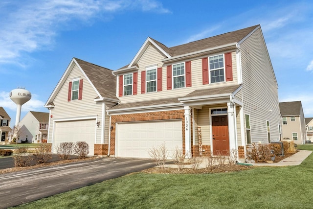 view of front of property featuring a garage, driveway, a front yard, and brick siding