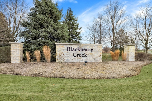 community / neighborhood sign with a yard