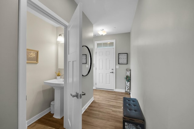 corridor with baseboards and wood finished floors