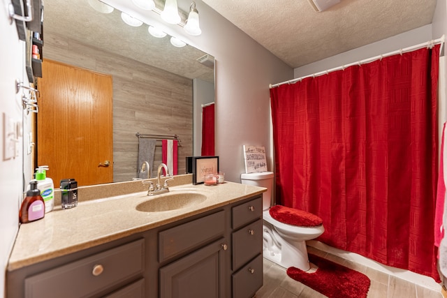 bathroom with curtained shower, toilet, a textured ceiling, vanity, and tile patterned floors