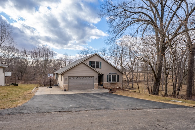 view of front of home with driveway, stone siding, and a front yard