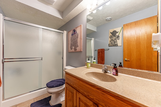 bathroom with a textured ceiling, a shower stall, and tile patterned floors