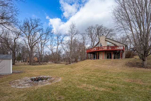 view of yard featuring an outdoor fire pit, an outdoor structure, and a deck