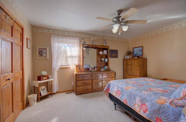 bedroom featuring light colored carpet and a ceiling fan
