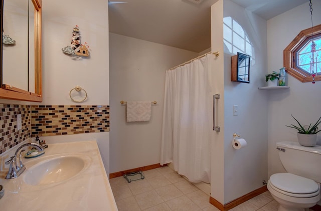 bathroom featuring baseboards, toilet, a shower with curtain, tile patterned floors, and vanity