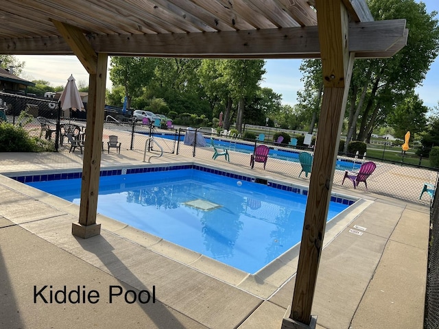 community pool with fence and a patio area