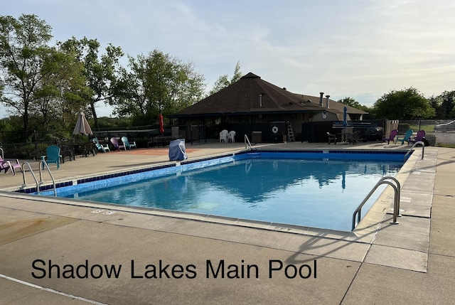 community pool featuring fence and a patio area