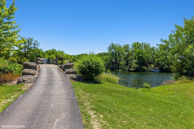 view of asphalt driveway with a water view