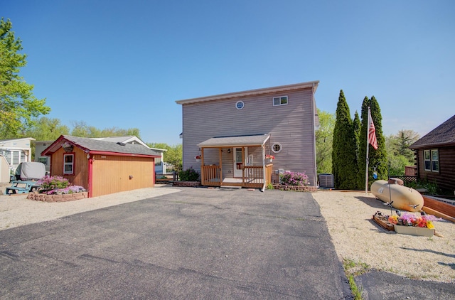 view of front of house featuring central AC unit, an outbuilding, and a wooden deck