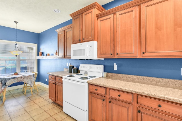 kitchen featuring brown cabinets, decorative light fixtures, white appliances, light tile patterned floors, and light stone countertops