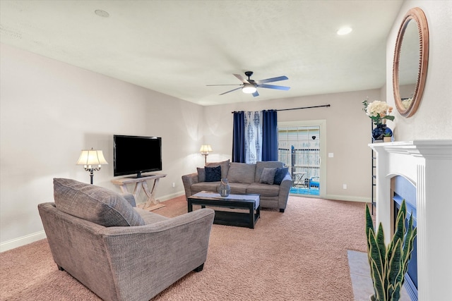 living area with ceiling fan, a fireplace with flush hearth, baseboards, and light carpet