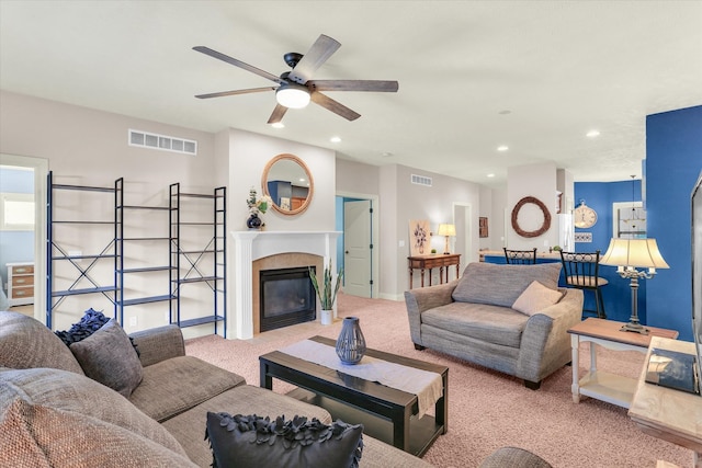 living room with recessed lighting, visible vents, carpet, and a glass covered fireplace