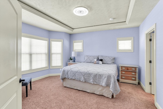 bedroom with baseboards, a raised ceiling, and light carpet