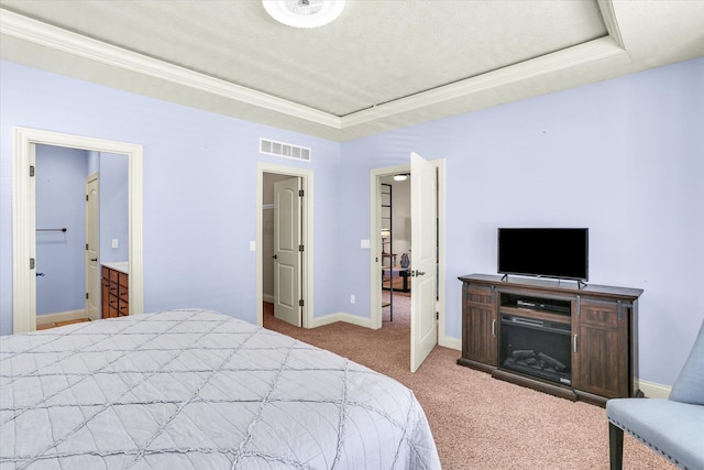 carpeted bedroom featuring visible vents, baseboards, crown molding, and a tray ceiling