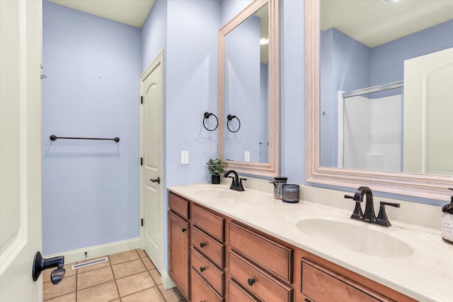 bathroom featuring tile patterned flooring, a stall shower, visible vents, and a sink