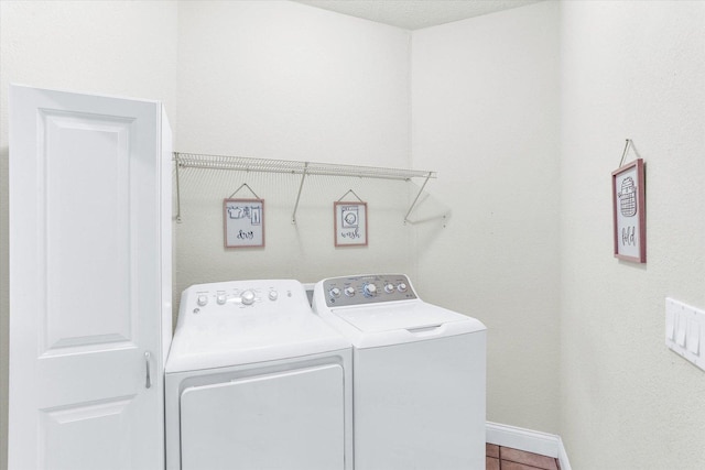 laundry area featuring tile patterned flooring, laundry area, independent washer and dryer, and baseboards