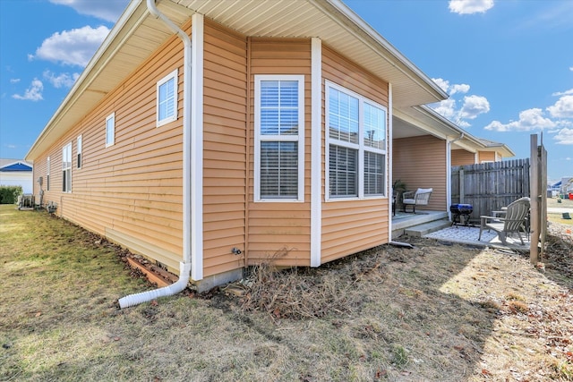 view of side of property featuring a patio and fence