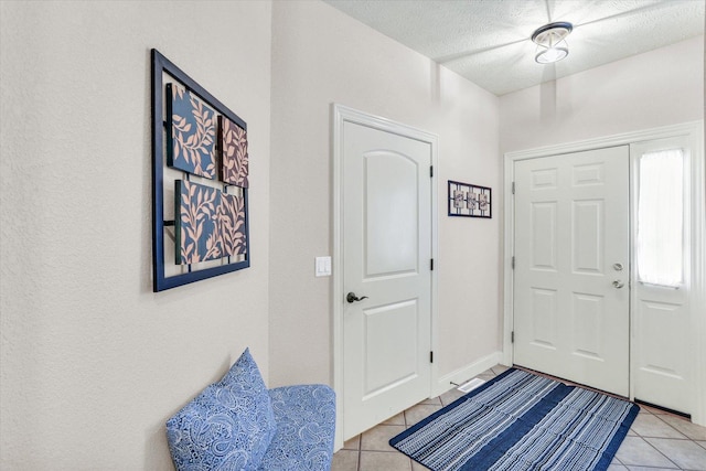 foyer with light tile patterned flooring and a textured ceiling