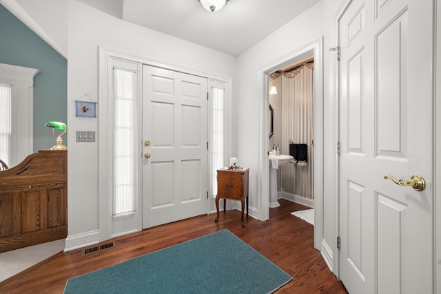 entrance foyer with visible vents, baseboards, and dark wood-style flooring