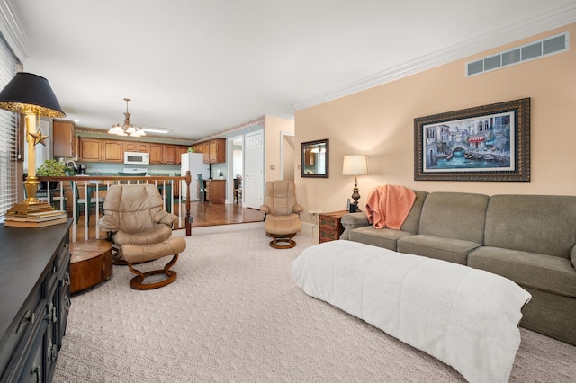 living area with visible vents, light colored carpet, an inviting chandelier, and crown molding