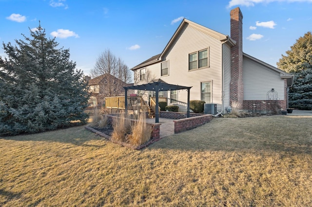 back of property with a yard, a patio, central AC unit, and a chimney