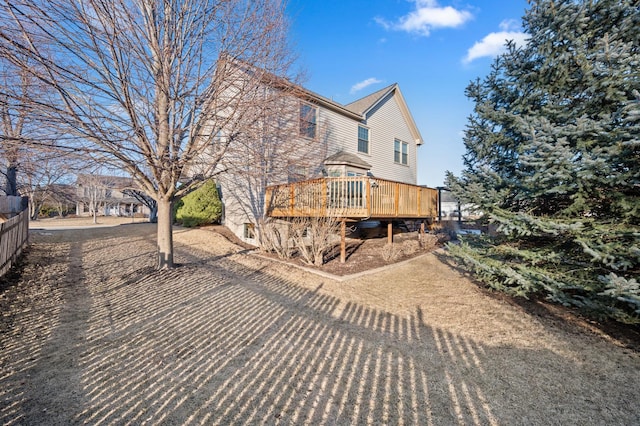 rear view of property with a deck and fence