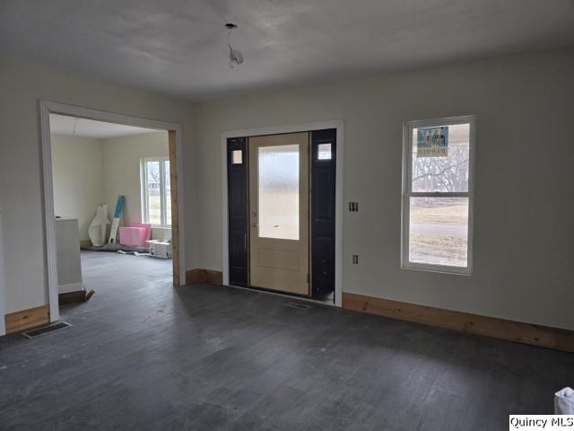 entryway with wood finished floors, visible vents, and baseboards