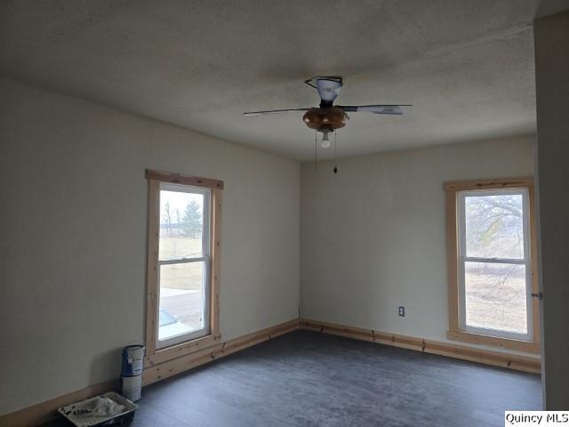 empty room featuring ceiling fan and plenty of natural light