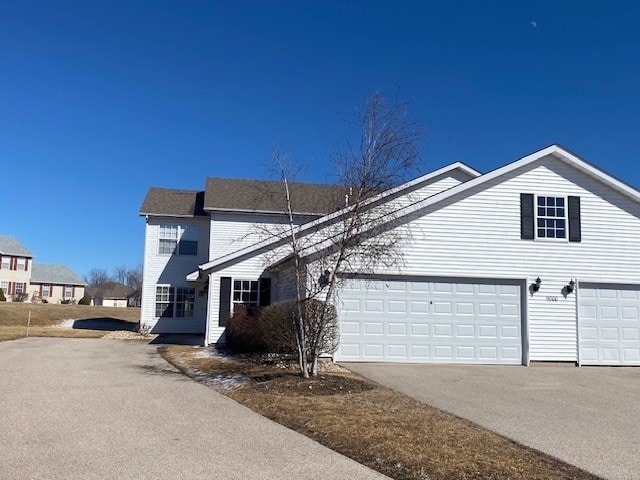 traditional home featuring a garage and driveway