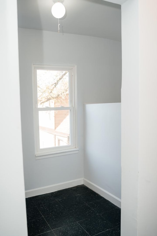 empty room featuring dark floors and baseboards