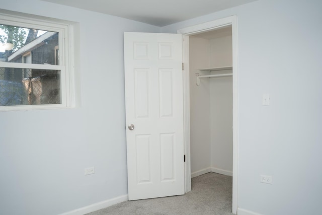 unfurnished bedroom with a closet, baseboards, and carpet flooring