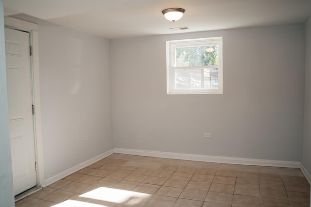 unfurnished room featuring baseboards, visible vents, and light tile patterned flooring