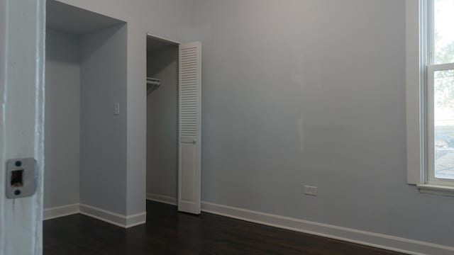 unfurnished bedroom with dark wood-style floors and baseboards