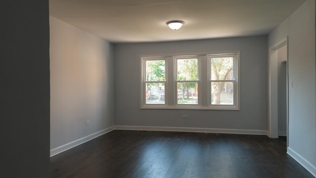 spare room with dark wood-style floors and baseboards