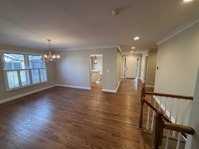 unfurnished room with an inviting chandelier, baseboards, dark wood finished floors, and crown molding